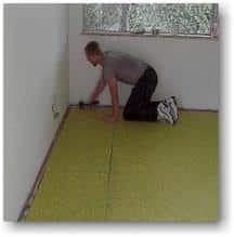 Affixing the pad to a wood floor using a hammer tacker.